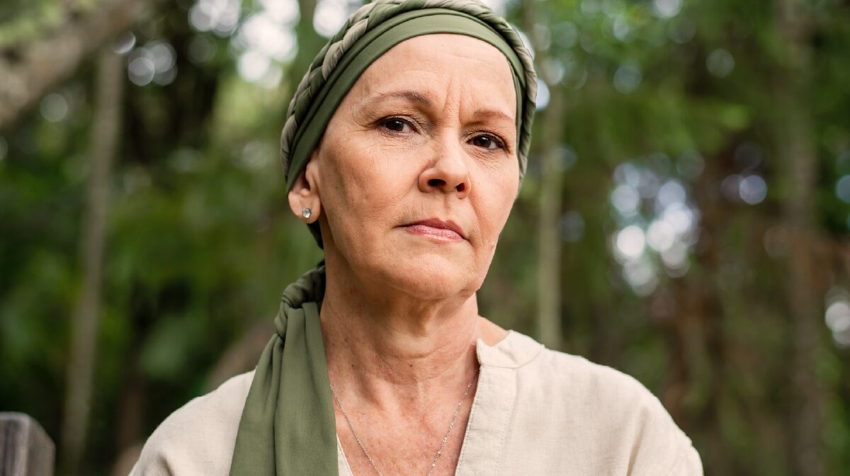 Closeup of a female cancer care patient looking towards the camera.