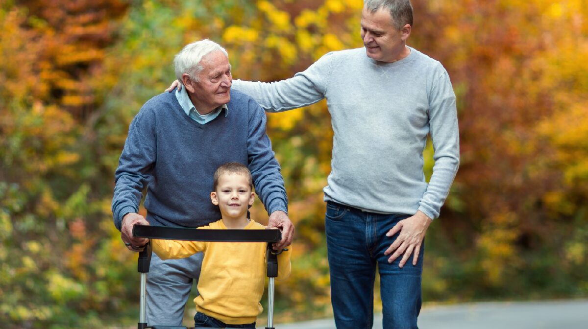 A mature man and his young son an older man during a walk outside.
