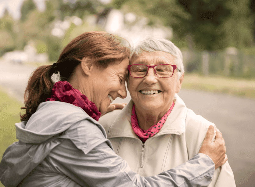 Older woman hugging her mother.