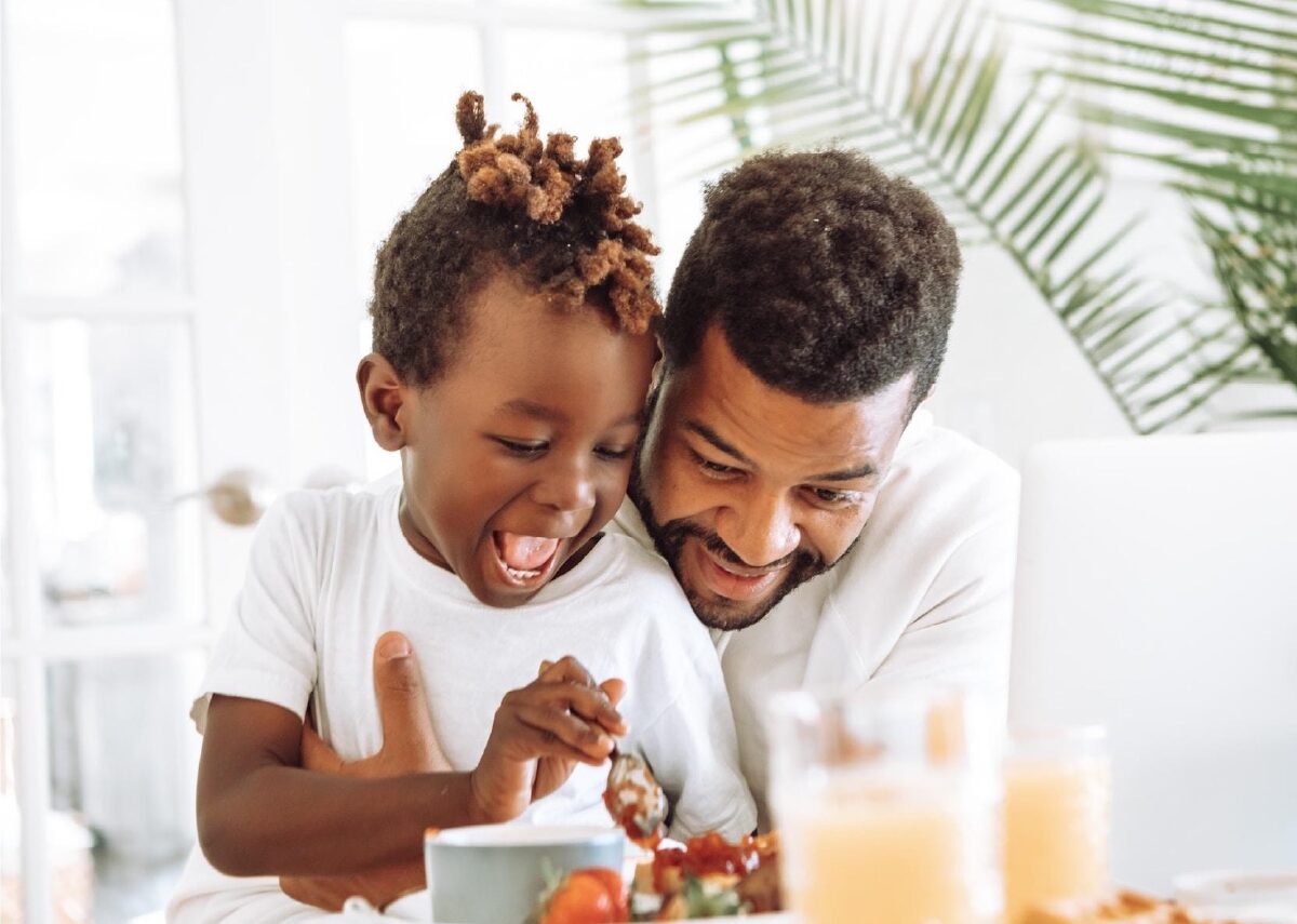 Father and his young child playing with their food.
