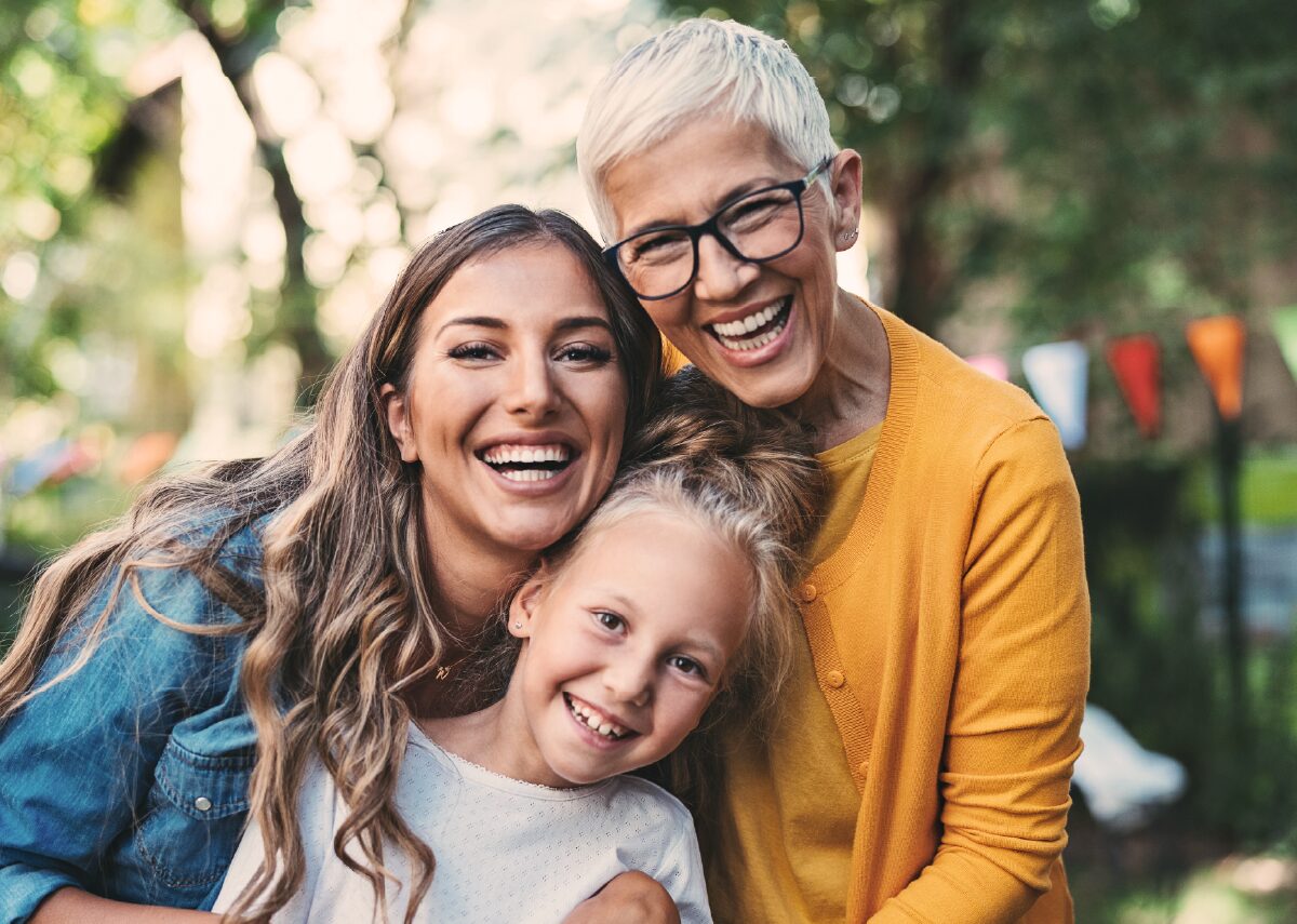 Sandwich generation caregiver posing for a photo with her mother and daughter.