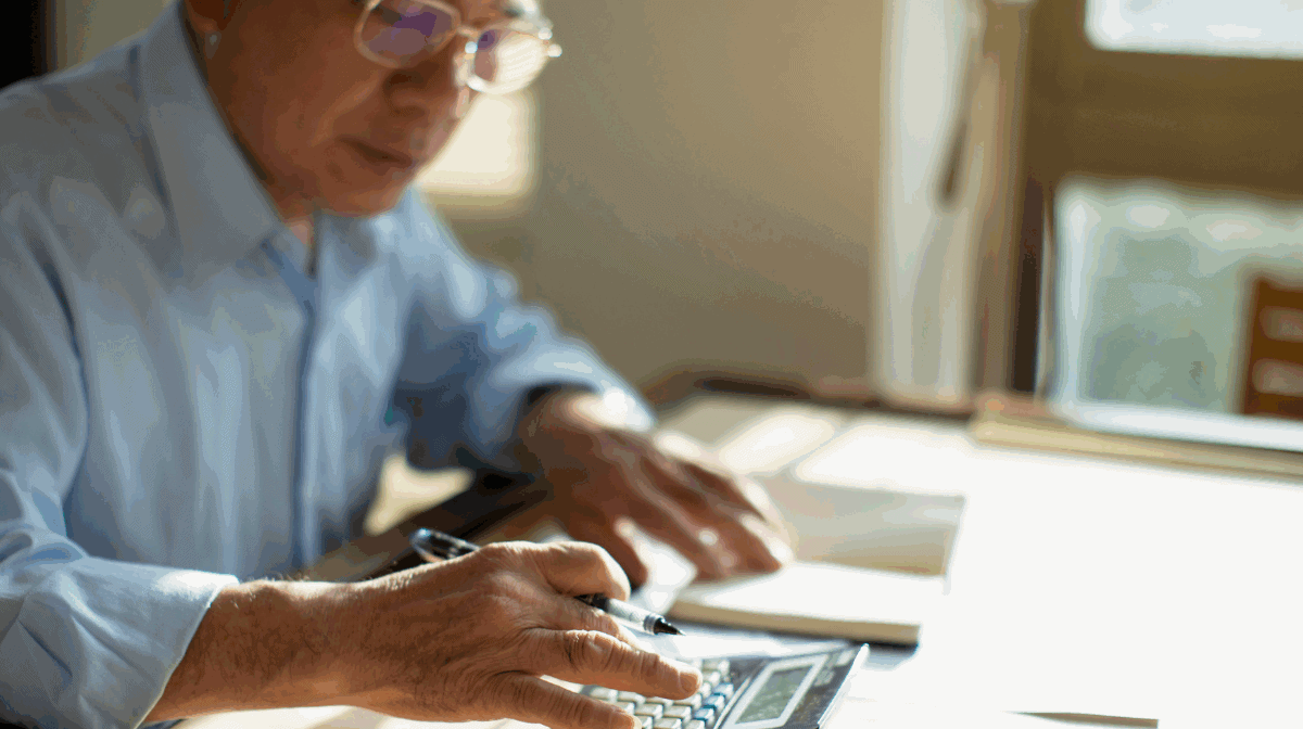 Man adding up medical expenses on a calculator.