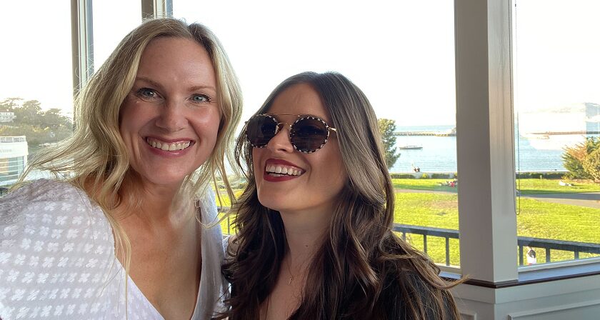 Close-up of two female employees smiling.