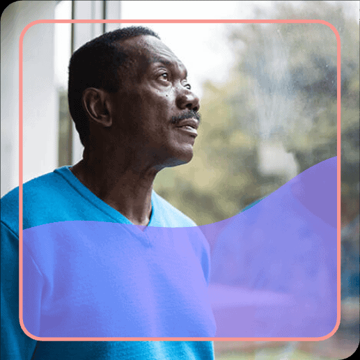 Elderly man gazing out a window.