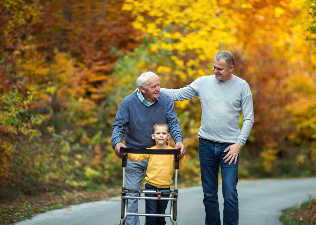 Father, son and grandad out for a walk in the park together.